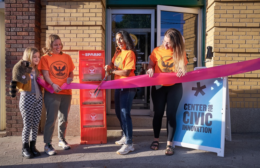 DPRI staff cutting a ribbon in front of the first Spark newsstand outside the Center for Civic Innovation